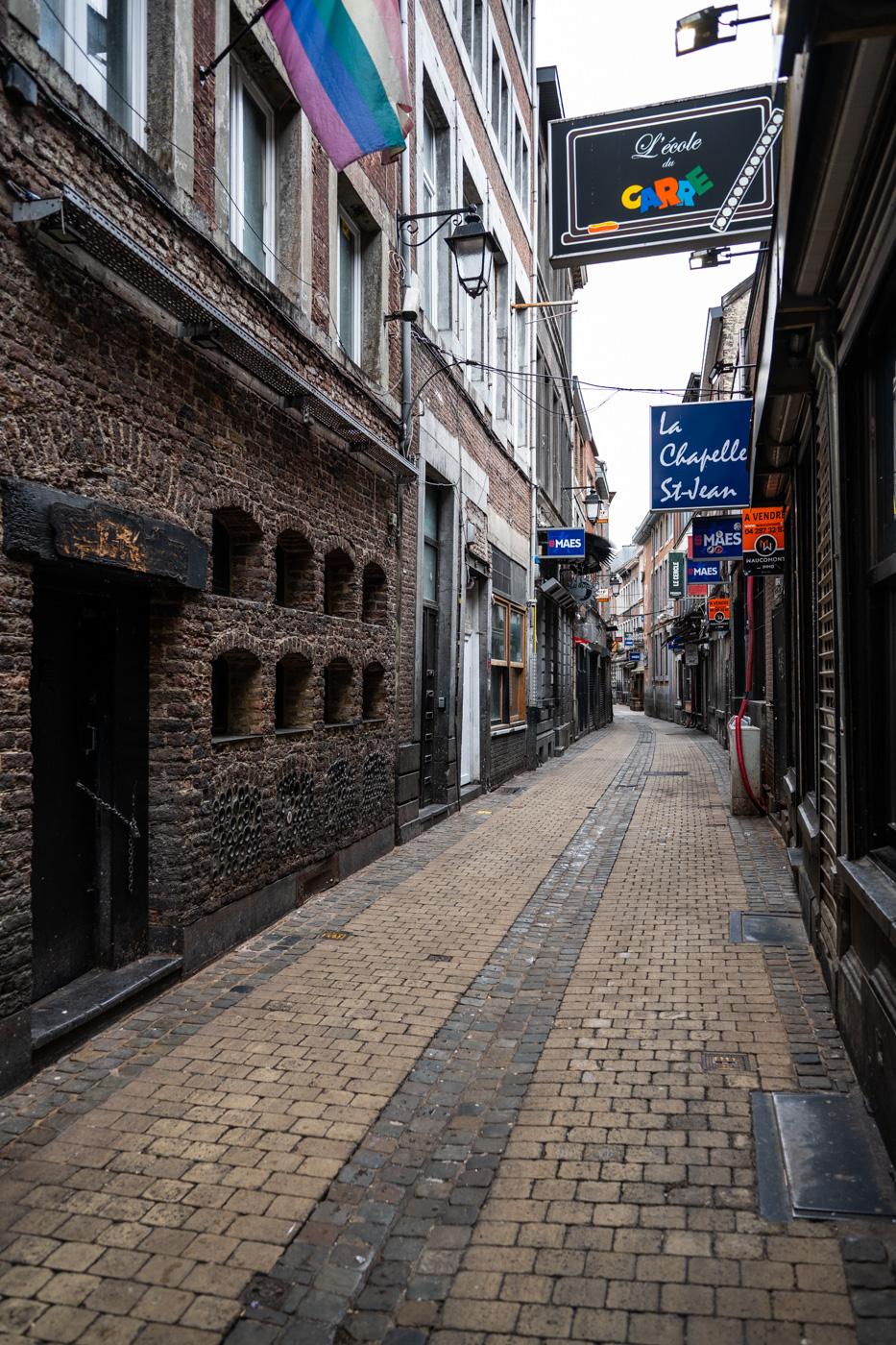 Enge Gasse in der Innenstadt von Lüttich, hier ist ein Bereich mit Klubs und Bars. Alte Gebäude mit ein wenig Aussenwerbung sind zu sehen.