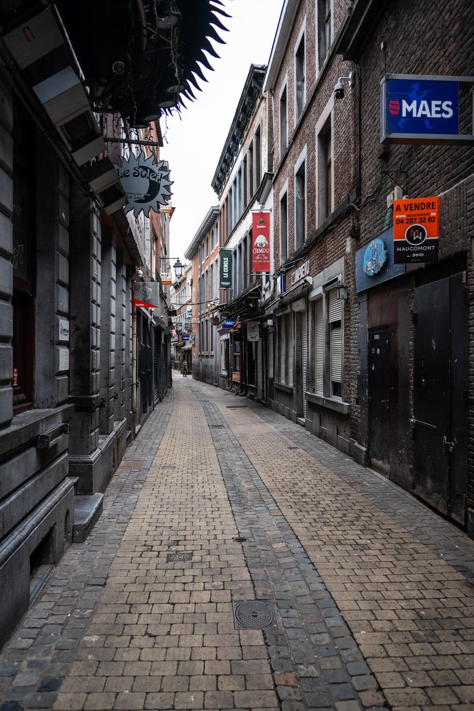 Enge Gasse in der Innenstadt von Lüttich, hier ist ein Bereich mit Klubs und Bars. Alte Gebäude mit ein wenig Aussenwerbung sind zu sehen.