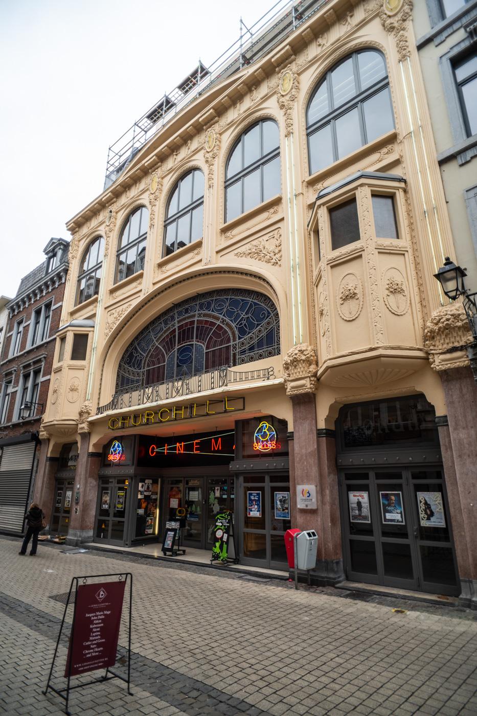 Ein Kino in der Innenstadt von Lüttich in einem schönen alten Gebäude in Ockerfarben.