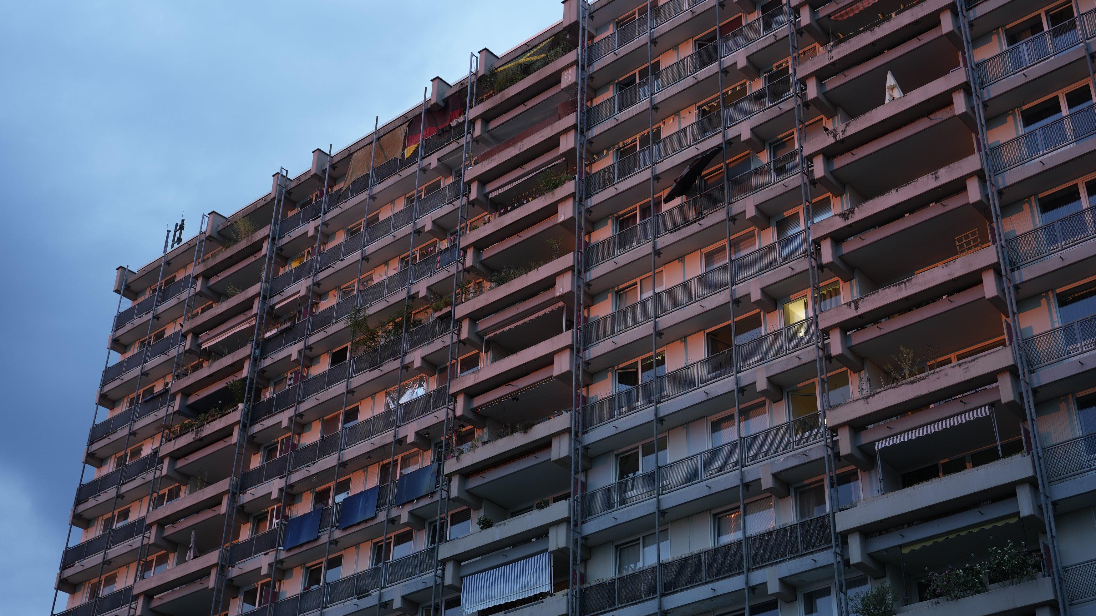 multilevel apartment block, probably 1980s, in the light of the setting sun. lots of greebles.