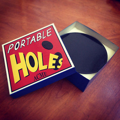 an open box labelled ACME portable holes
containing a black circle