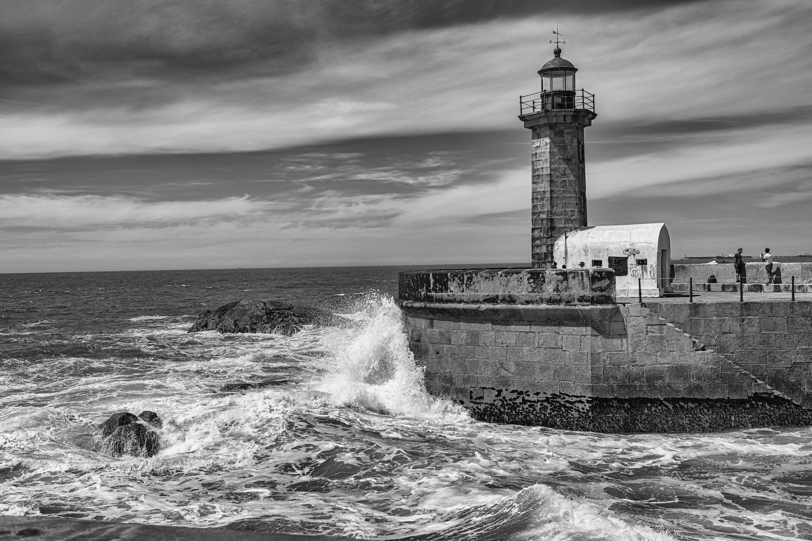 Leuchtturm von Falgueiras, Portugal, in bewegter See. Bild in schwarz-weiss.